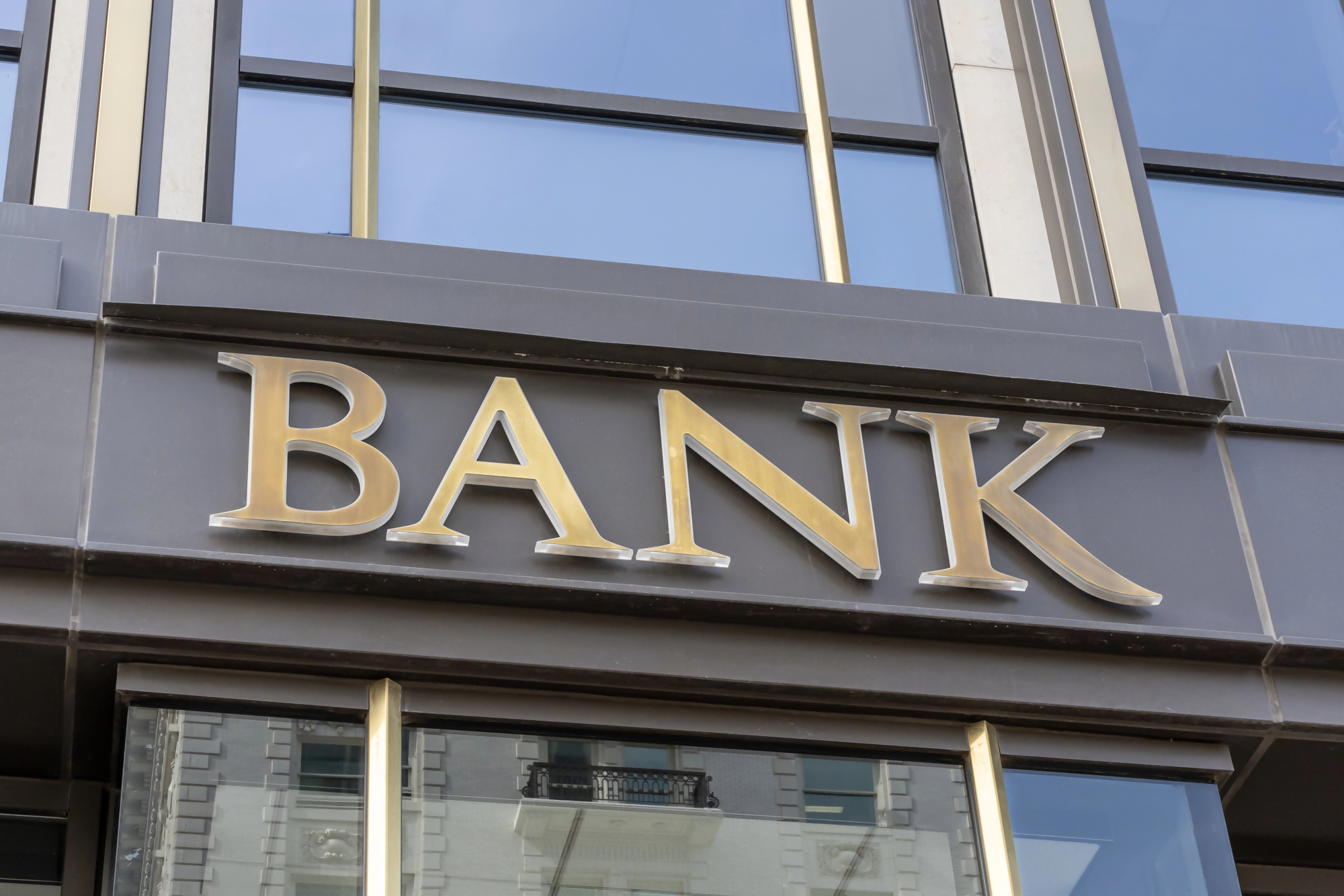 Fasada budynku banku z dużym napisem BANK, ilustracja nawiązująca do tematu bankowy tytuł egzekucyjny oraz działania instytucji finansowych.