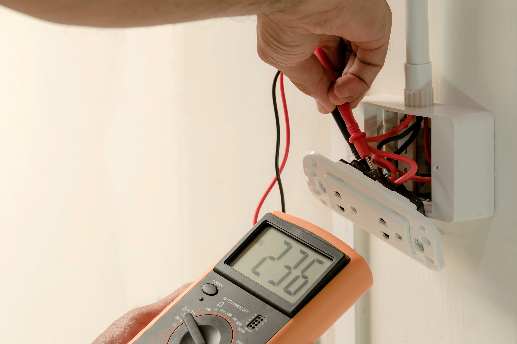 Brak odbioru domu a kredyt hipoteczny – elektryk sprawdza instalację elektryczną w nowym domu, co może opóźnić odbiór techniczny nieruchomości i wpływać na warunki wypłaty kredytu hipotecznego.