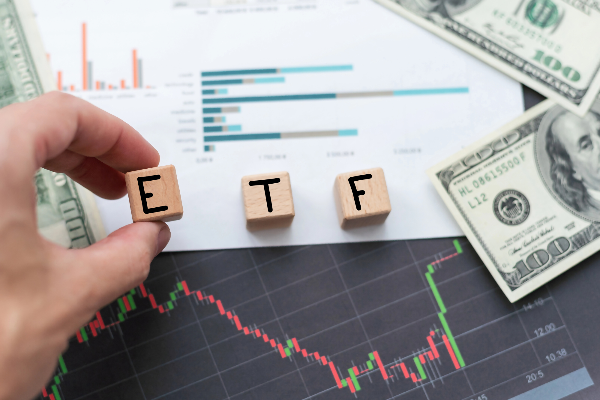 Fundusze ETF – wykresy giełdowe, banknoty dolarowe i kostki z napisem ETF, symbolizujące inwestowanie w fundusze ETF oraz analizę finansową.