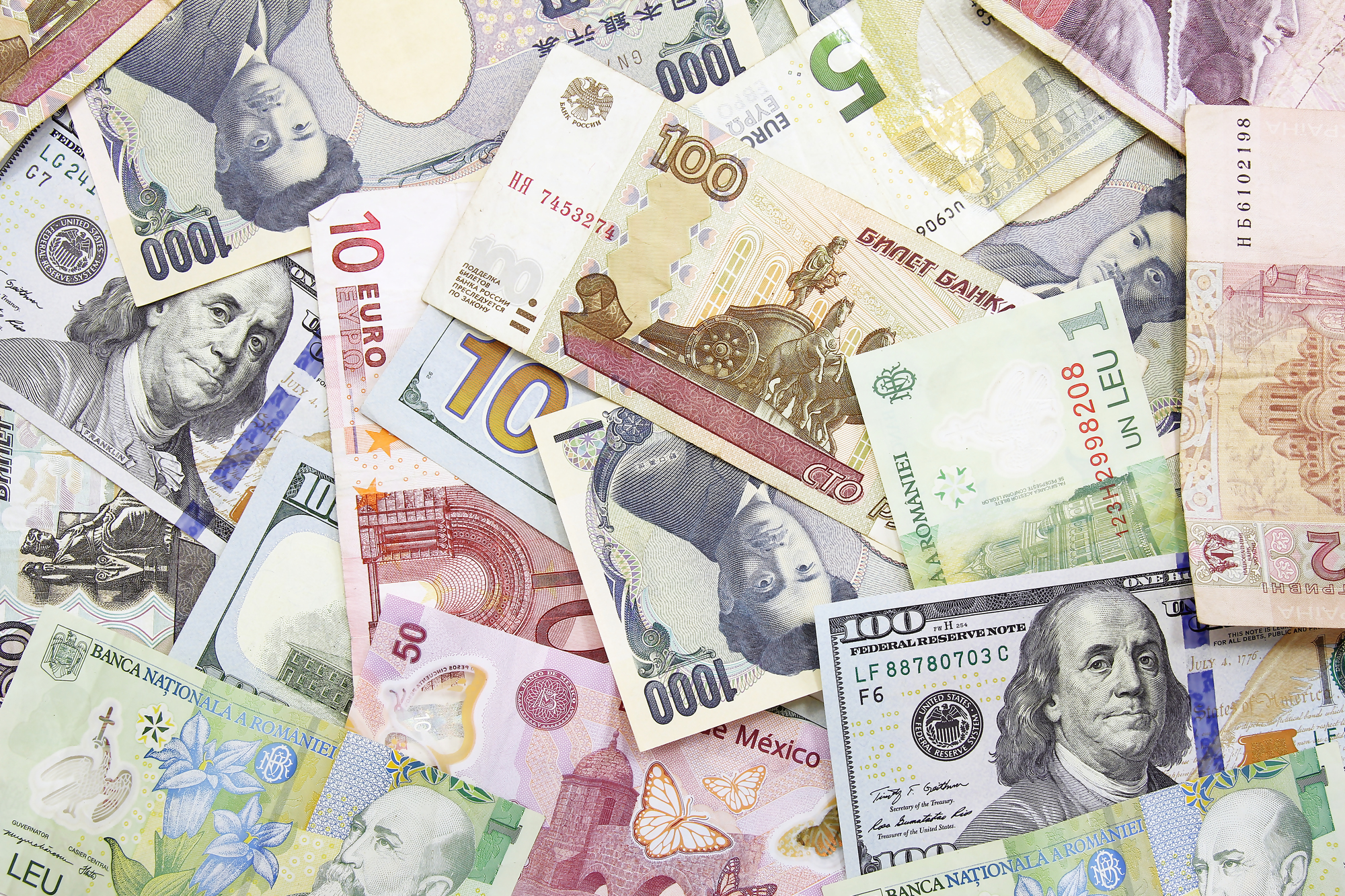 Różnorodne banknoty z różnych krajów, w tym euro, dolar amerykański i inne waluty – czy warto trzymać oszczędności w euro? Obrazek ilustruje temat dywersyfikacji oszczędności i wyboru waluty do przechowywania kapitału.