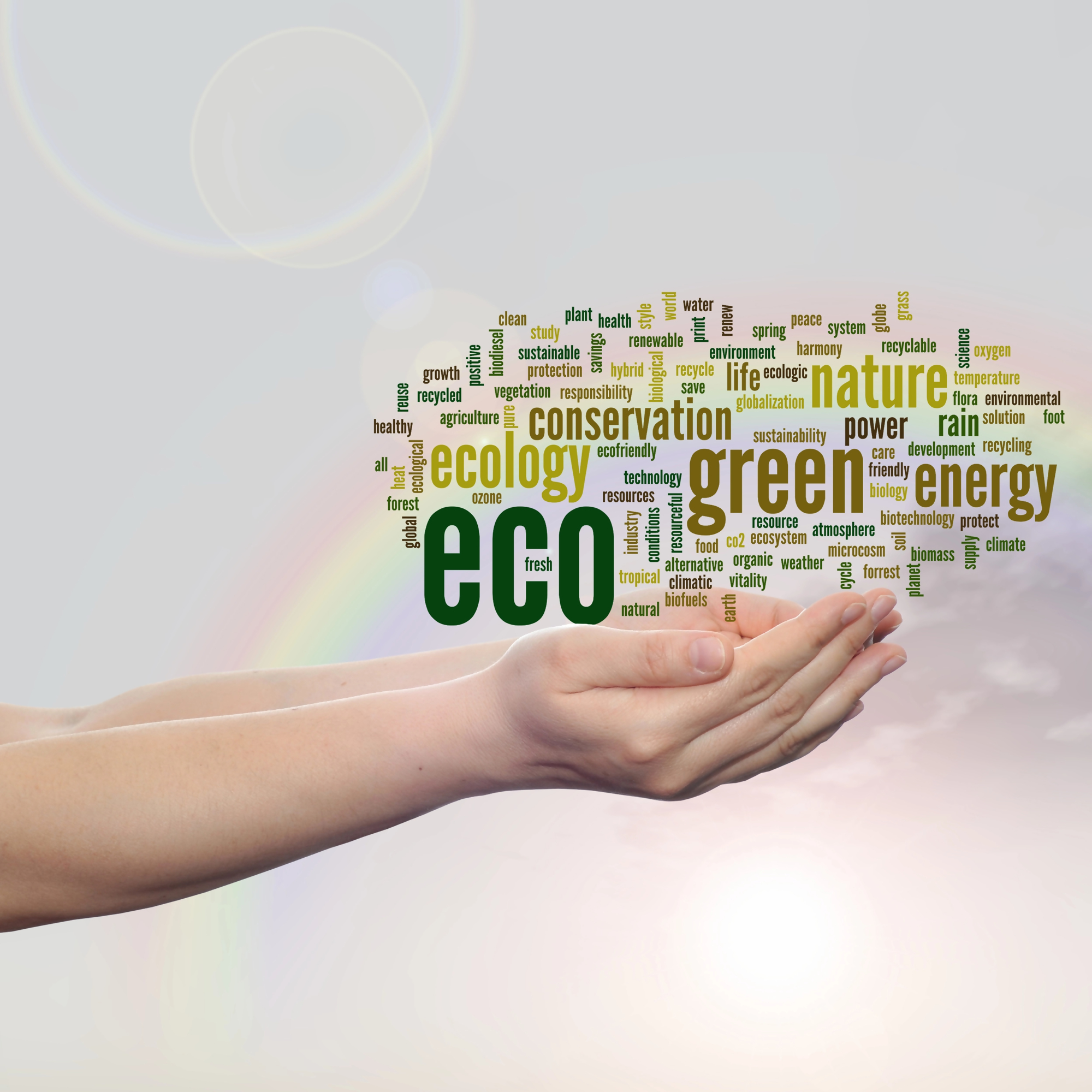 Dłonie trzymające chmurę słów związanych z ekologią, energią, naturą i zielonym stylem życia, nawiązujące do zjawiska greenwashing w kontekście ekologicznego marketingu i ochrony środowiska.