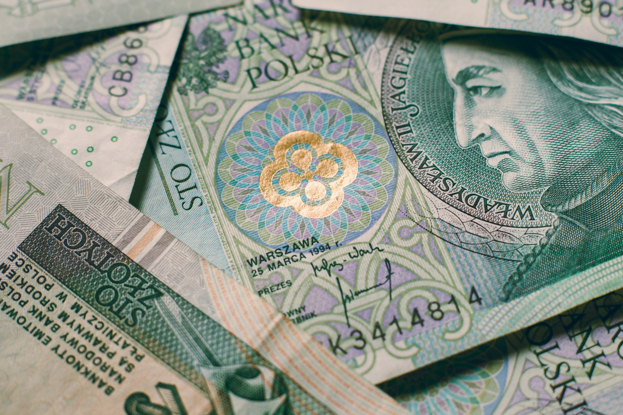 Wymiana zniszczonego banknotu – obraz przedstawiający polskie banknoty stuzłotowe, częściowo zniszczone, ilustrujący temat wymiany zniszczonych banknotów w Polsce.